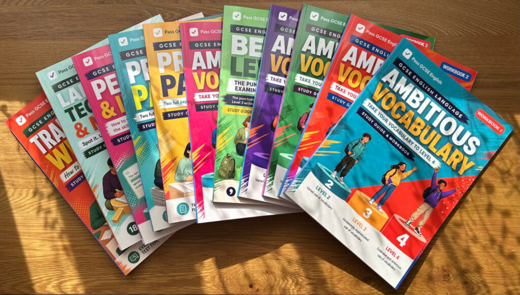 Eleven printed Pass GCSE English workbooks arranged on a wooden desk